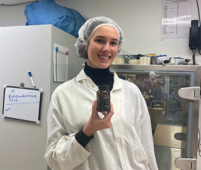 Monday Muse founder holding a product in the formulation lab